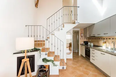 a kitchen with a staircase and a living room at Raposeira Cottage in Sagres