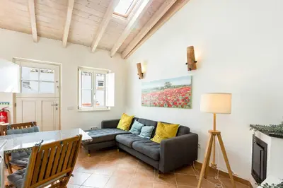 a living room with a couch and a table at Raposeira Cottage in Sagres