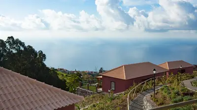 a house on a hill with clouds in the sky at Atrio in Estreito da Calheta