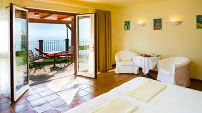 a bedroom with a bed and a balcony with a table and chairs at Atrio in Estreito da Calheta