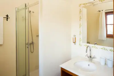 a bathroom with a sink and a shower with a mirror at Atrio in Estreito da Calheta
