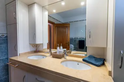a bathroom with two sinks and a mirror at Casa Do Dino in Ribeira Brava