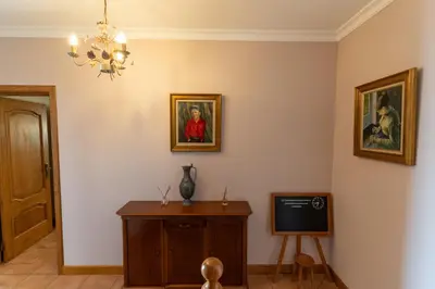 a living room with a television and paintings on the walls at Casa Do Dino in Ribeira Brava
