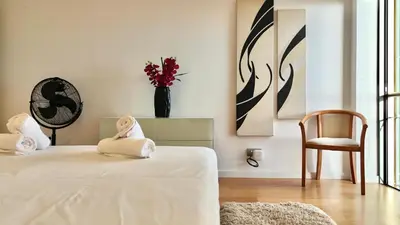 a bedroom with two beds and a vase with flowers at Forum Sky in Funchal