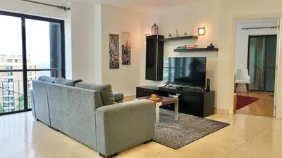a living room with a couch and a television at Forum Sky in Funchal