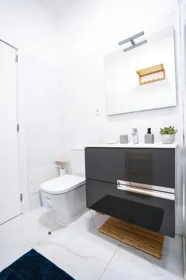 a white bathroom with a toilet and a sink at CITY OASlS FUNCHAL APARTMENT & STUDIO in Funchal