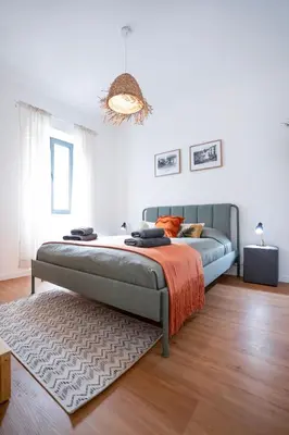 a bedroom with a bed and a rug at CITY OASlS FUNCHAL APARTMENT & STUDIO in Funchal