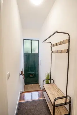 a hallway with a green door and a bench at CITY OASlS FUNCHAL APARTMENT & STUDIO in Funchal