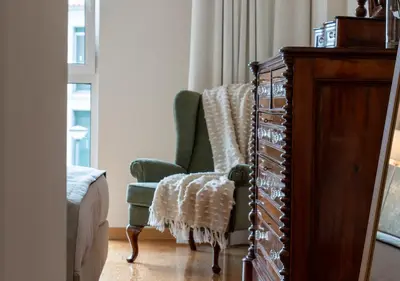 a kitchen with white cabinets and bar stools at Funcho 91, cozy apartment in the heart of the city in Funchal