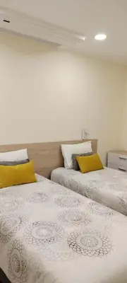 two beds with yellow pillows in a bedroom at Beautiful View - Arco da Calheta - Ilha da Madeira in Arco da Calheta