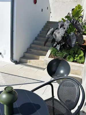 a chair and a table in front of a staircase at NEW! casa L, ocean view private pool Villa in Ponta do Sol