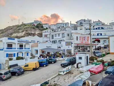 a group of cars parked in front of buildings at Casa do Burgau in Burgau