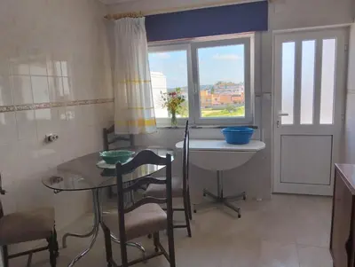 a small kitchen with a table and a window at Casa do Burgau in Burgau
