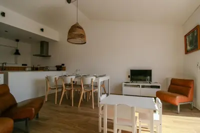 a living room with a table and chairs and a kitchen at FLH Praia da Luz Town House in Lagos