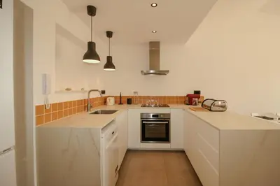 a kitchen with white cabinets and a sink at FLH Praia da Luz Town House in Lagos