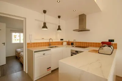 a kitchen with white cabinets and a counter top at FLH Praia da Luz Town House in Lagos