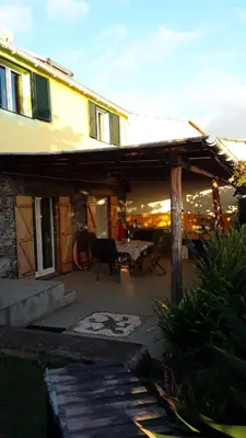 a house with a patio with a table and chairs at A charming spot in Estreito da Calheta