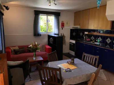 a kitchen and living room with a table and a couch at A charming spot in Estreito da Calheta