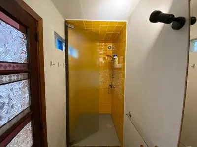 a bathroom with a shower with a yellow tile at A charming spot in Estreito da Calheta