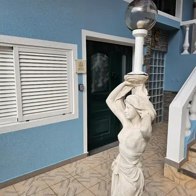 a statue of a woman holding a street light at JoLi Larano - BBQ In in Machico