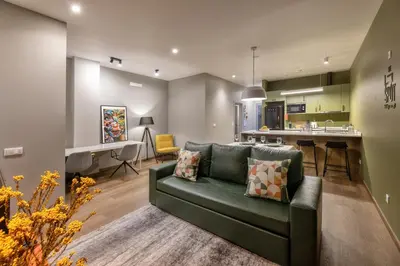 a living room with a green couch and a kitchen at THE SPOT- holiday concept in Santa Cruz
