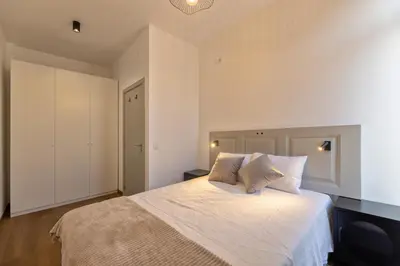 a bedroom with a bed with white sheets and pillows at THE SPOT- holiday concept in Santa Cruz
