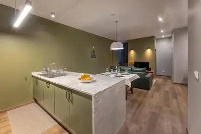 a kitchen with a counter and a living room at THE SPOT- holiday concept in Santa Cruz