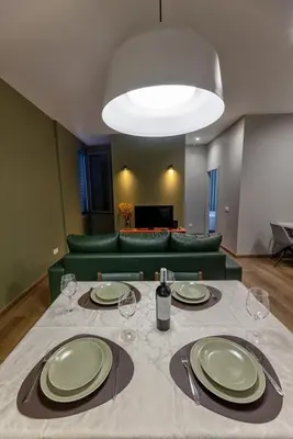 a table with plates and wine glasses and a couch at THE SPOT- holiday concept in Santa Cruz