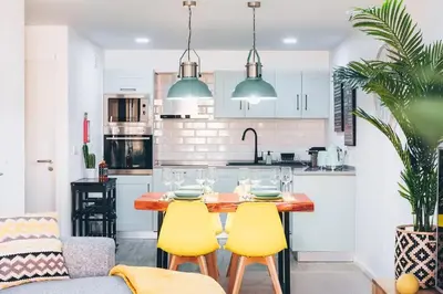 a kitchen with a wooden table and yellow chairs at Funchal City Yellow Townhouse and Terrace in Funchal