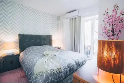 a bedroom with a bed and a vase with flowers at Funchal City Yellow Townhouse and Terrace in Funchal