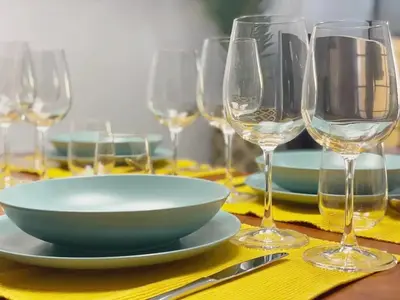a table with a plate and wine glasses on it at Funchal City Yellow Townhouse and Terrace in Funchal