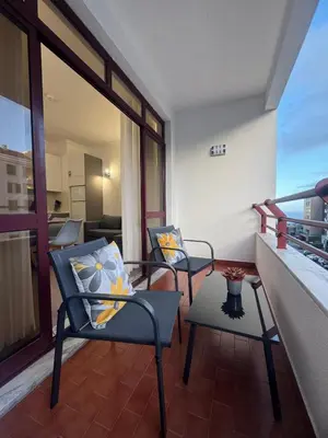 two chairs and a table on a balcony at Ávila Holidays in Funchal