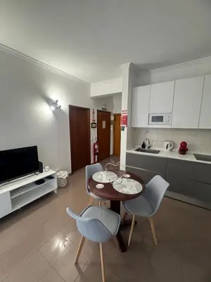 a living room with a table and chairs and a kitchen at Ávila Holidays in Funchal