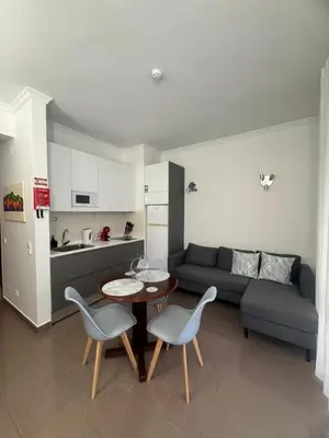a living room with a couch and a table and chairs at Ávila Holidays in Funchal