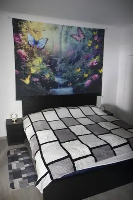 a bed in a room with a painting on the wall at House Villa Butterfly in Santana