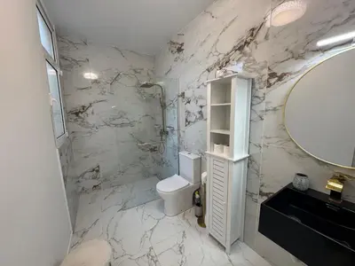 a bathroom with a toilet and a sink and a mirror at Charming Seaside Flat in Paul do Mar