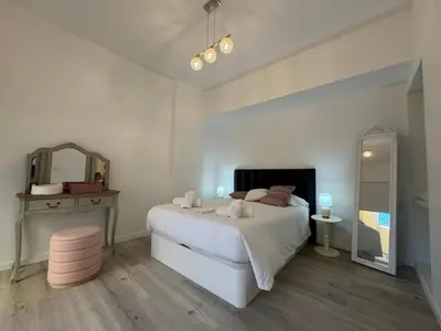 a bedroom with a white bed and a mirror at Charming Seaside Flat in Paul do Mar