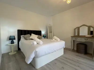 a bedroom with a white bed and a mirror at Charming Seaside Flat in Paul do Mar
