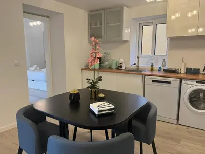a kitchen with a black table and chairs in a kitchen at Charming Seaside Flat in Paul do Mar