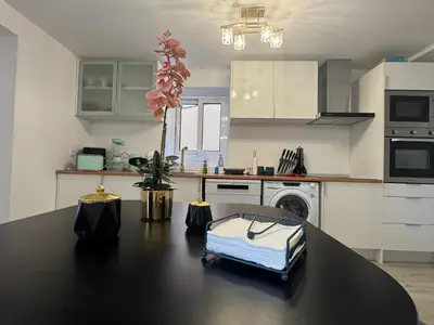 a kitchen with a black table with a flower on it at Charming Seaside Flat in Paul do Mar