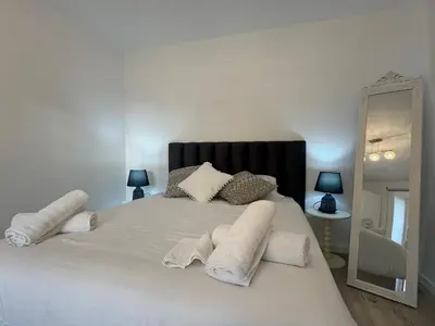 a bedroom with a large white bed with towels on it at Charming Seaside Flat in Paul do Mar