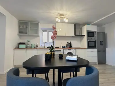 a kitchen with a table and two blue chairs at Charming Seaside Flat in Paul do Mar