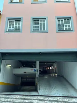 a large pink building with a parking garage at Carreira Vicente by Olá Madeira in Funchal
