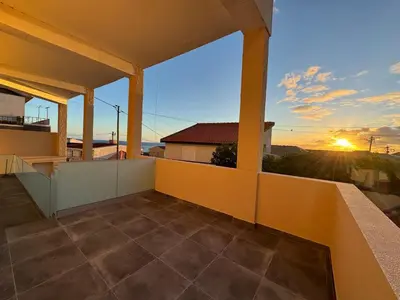 a view from the balcony of a house with the sunset at Charming Sunset flat in Paul do Mar