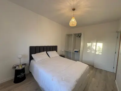 a bedroom with a large white bed and a light at Charming Sunset flat in Paul do Mar