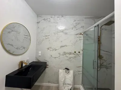 a bathroom with a sink and a glass shower at Charming Sunset flat in Paul do Mar
