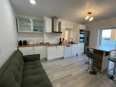 a living room with a couch and a kitchen at Charming Sunset flat in Paul do Mar