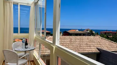 a balcony with a table and chairs and a view of the ocean at Domingos Reis Studio in São Vicente
