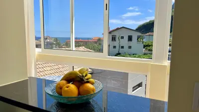 a bowl of oranges on a table with a window at Domingos Reis Studio in São Vicente