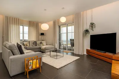 a kitchen and dining room with a black table and chairs at Belo Horizonte in Estreito da Calheta